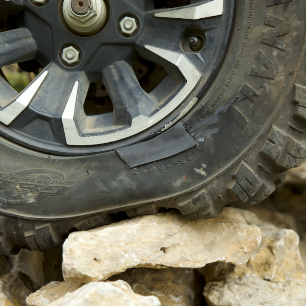 Off-road tire on a rocky terrain with a sidewall tire patch